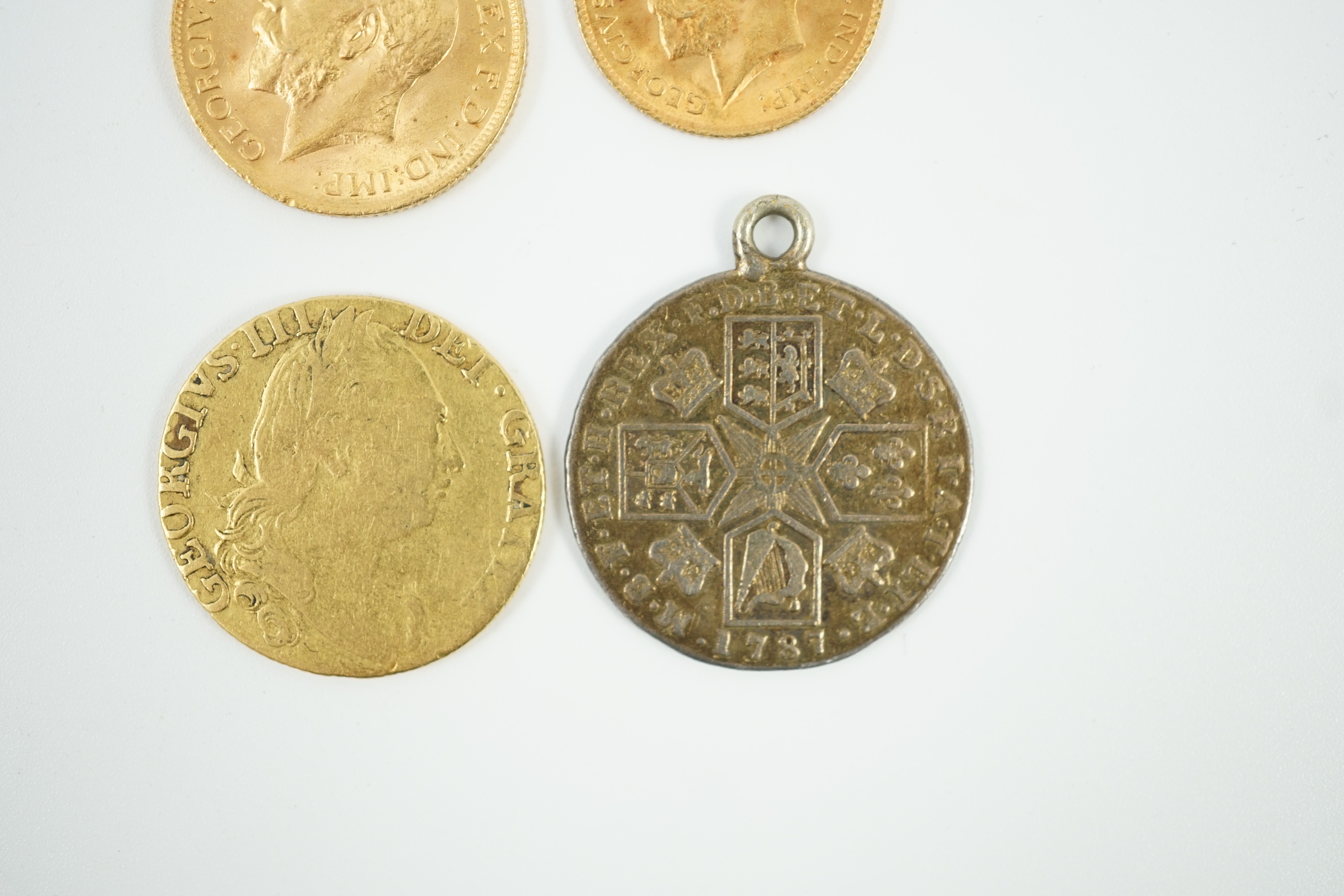 A George V 1915 gold sovereign and a 1915 gold half sovereign, a George III 1782 gold guinea(worn) and a George III 1787 shilling, with pendant mount.